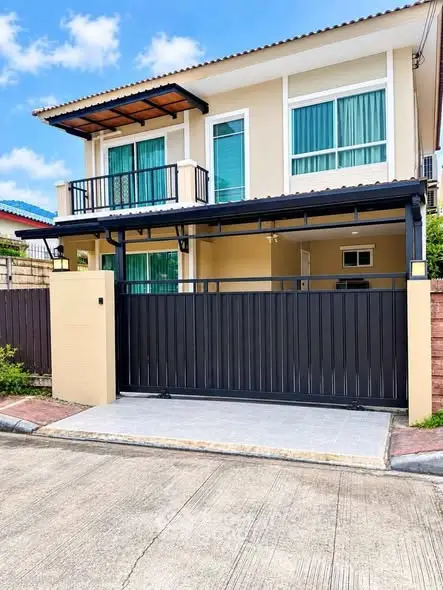 Modern two-story house with gated entrance and balcony, perfect for family living.