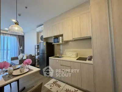 Modern open-layout kitchen and living room with stylish decor and natural light.
