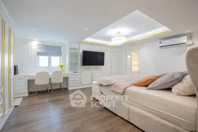 Luxurious bedroom with elegant decor, featuring a plush bed, stylish vanity, and modern lighting.