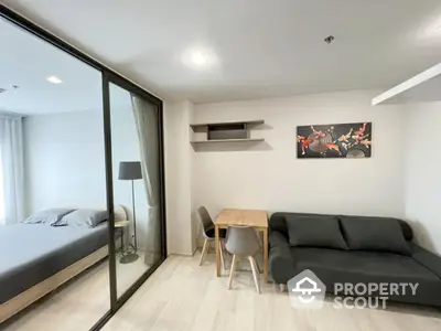 Modern studio apartment with glass partition, cozy living area, and stylish decor.