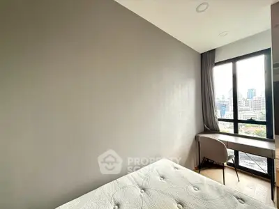 Modern bedroom with city view, featuring a cozy bed and a sleek desk by the window.