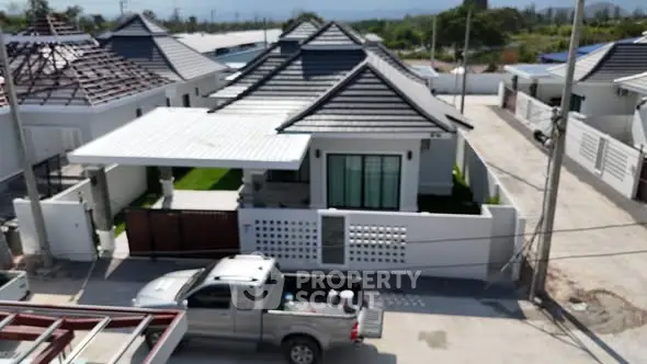 Modern single-story house with carport and landscaped yard in a suburban neighborhood.