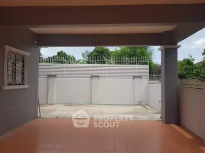 Spacious covered patio with tiled flooring and secure fencing, ideal for outdoor relaxation.