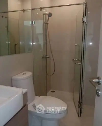 Modern bathroom with glass shower enclosure and sleek fixtures