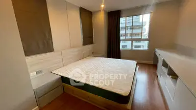 Modern bedroom with large window and built-in storage in urban apartment