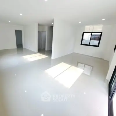 Spacious modern living room with glossy tile flooring and ample natural light.