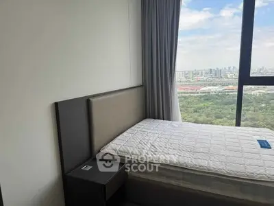 Modern bedroom with stunning city view from large window, featuring a single bed and nightstand.
