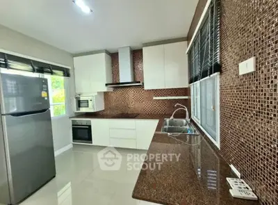 Modern kitchen with sleek appliances and stylish mosaic backsplash