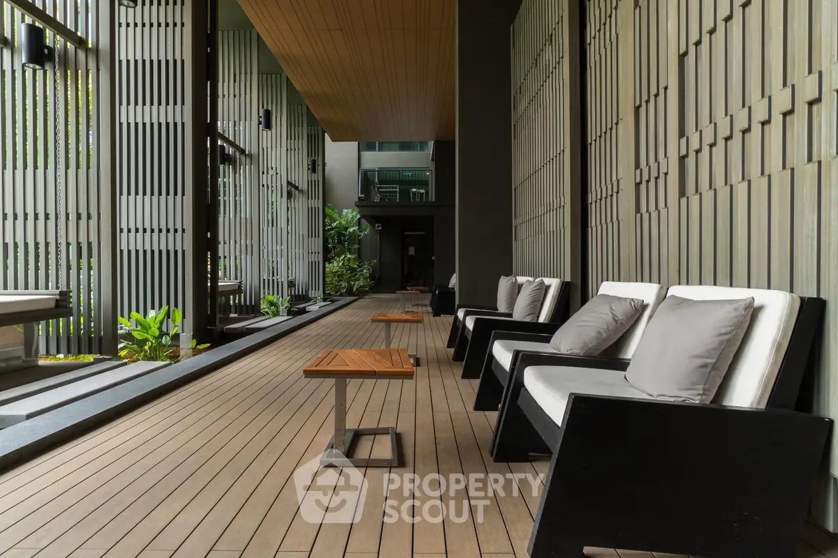 Luxurious modern building entrance with stylish seating and wooden deck flooring.