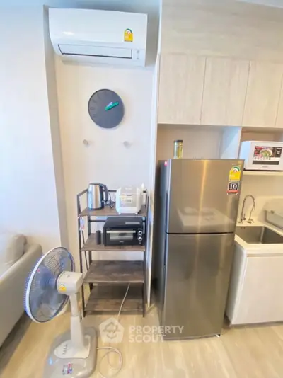 Modern kitchen with stainless steel fridge and appliances in compact layout