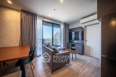 Modern living room with balcony view, stylish furniture, and natural light.