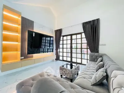Luxurious living room with modern decor, large TV, and elegant furniture in a bright, spacious setting.