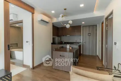 Modern open-layout kitchen and living area with stylish lighting and wood finishes