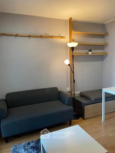 Cozy living room with modern furniture and stylish shelving, perfect for relaxation and entertaining.