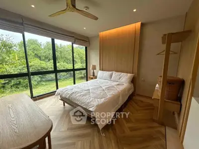 Modern bedroom with large windows and scenic view, featuring elegant wooden flooring and minimalist decor.