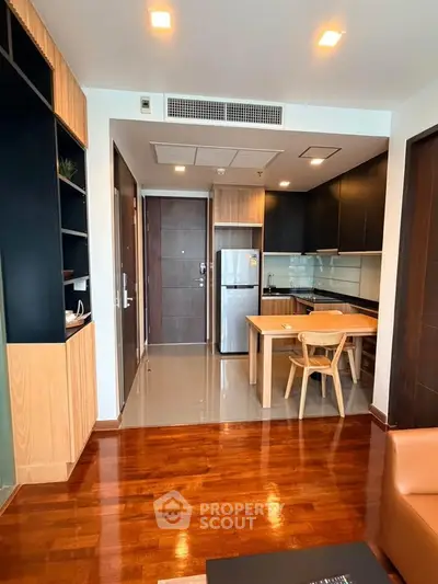 Modern open-layout kitchen with sleek cabinets and dining area in stylish apartment.