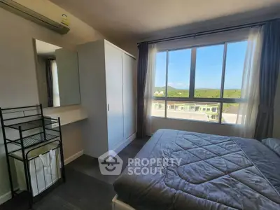 Bright bedroom with large window offering scenic views, featuring a cozy bed and modern wardrobe.