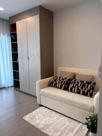 Cozy living room with modern sofa and built-in storage, perfect for urban living.