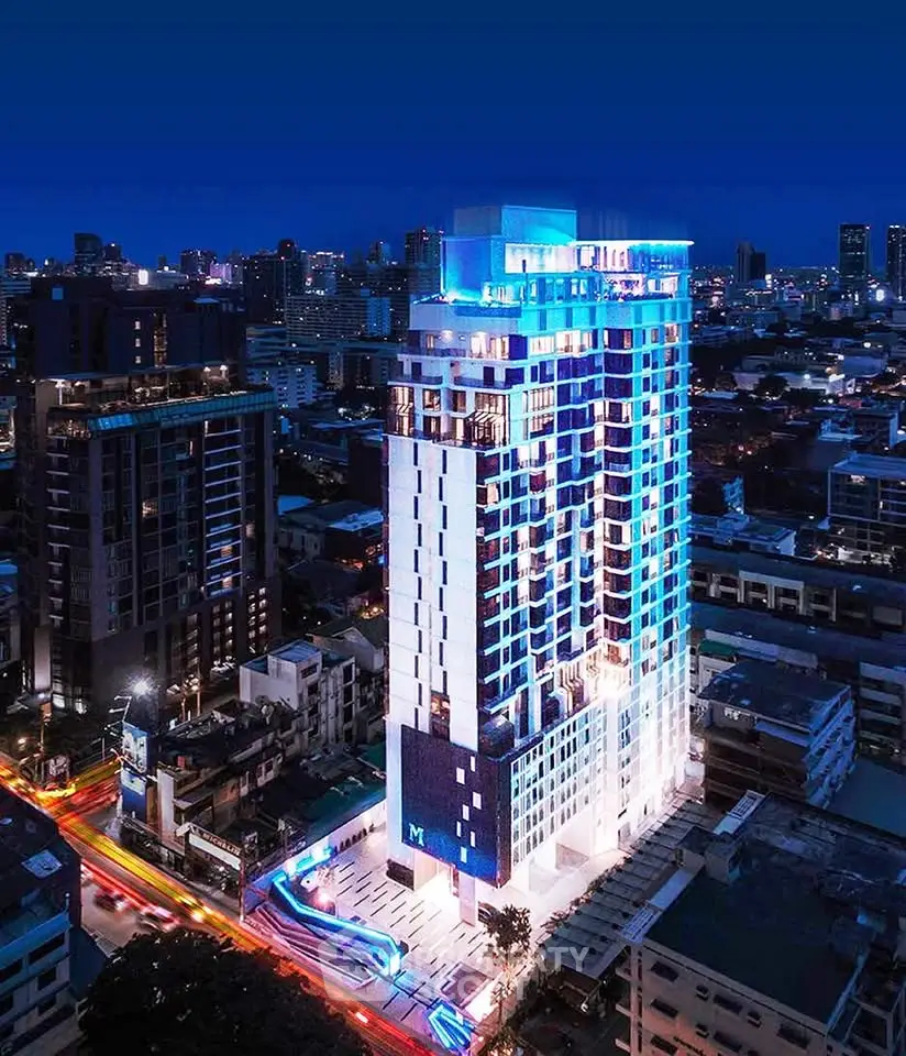 Stunning night view of a modern high-rise building in a vibrant cityscape.