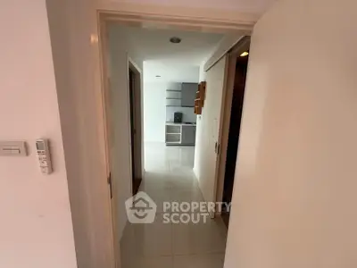 Modern apartment entrance with sleek kitchen view and tiled flooring.