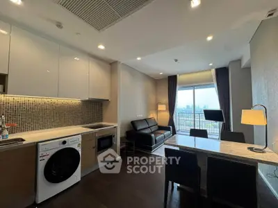 Modern open-layout kitchen and living room with city view, featuring sleek appliances and stylish decor.