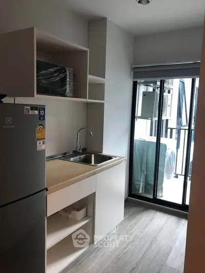 Modern kitchen with sleek cabinetry and stainless steel appliances in a bright apartment.