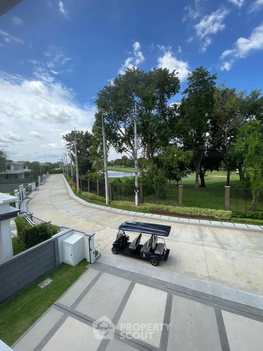 Luxurious residential area with golf course view and modern driveway.