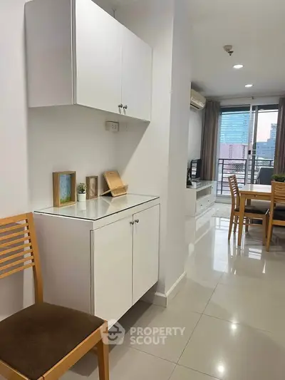 Modern apartment interior with open layout, dining area, and city view balcony.