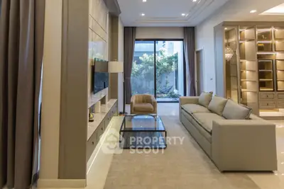 Luxurious living room with modern decor and large glass doors opening to garden view.