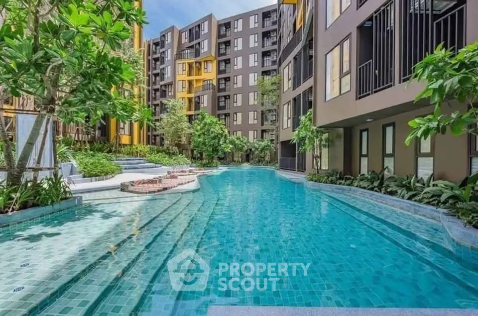 Luxurious apartment complex with stunning pool and lush greenery
