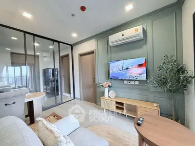 Modern living room with stylish decor and glass partition, featuring a wall-mounted TV and cozy seating.