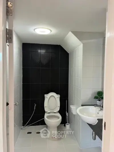 Modern bathroom with sleek black and white tiles and contemporary fixtures.