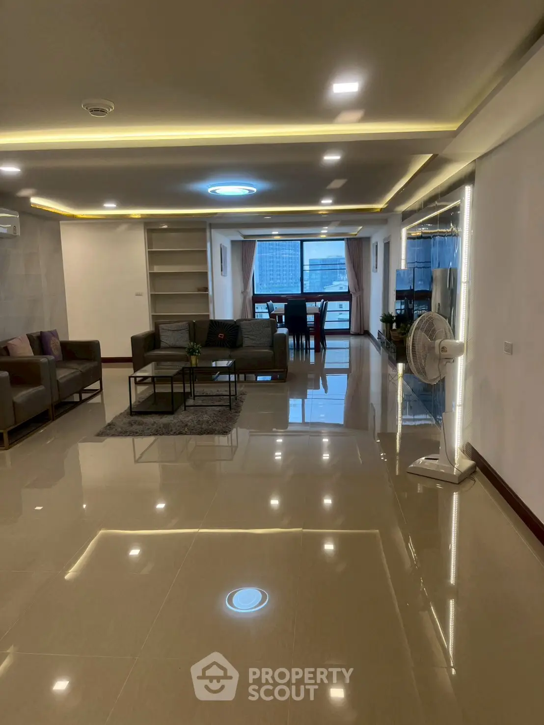Spacious modern living room with elegant lighting and city view, perfect for urban living.