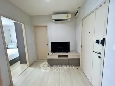 Modern apartment interior with sleek TV setup and air conditioning, showcasing minimalist design.