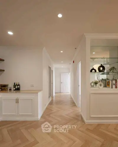 Spacious hallway with elegant herringbone flooring and modern decor
