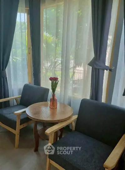 Cozy sitting area with natural light and garden view, perfect for relaxation.