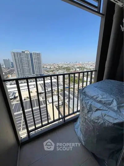 Stunning high-rise balcony view overlooking cityscape with clear blue skies, perfect for urban living.