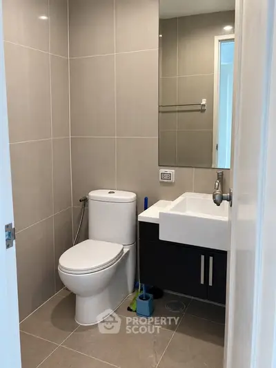 Modern bathroom with sleek fixtures and neutral tiles, perfect for a contemporary home.