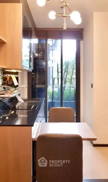 Modern kitchen with sleek design and balcony view, featuring open layout and contemporary lighting.