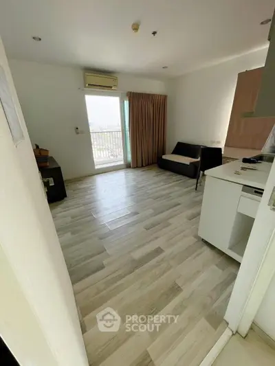 Spacious living room with modern flooring and balcony access in a stylish apartment.