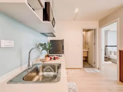 Modern kitchen with sleek design and open layout, featuring stainless steel sink and stylish decor.