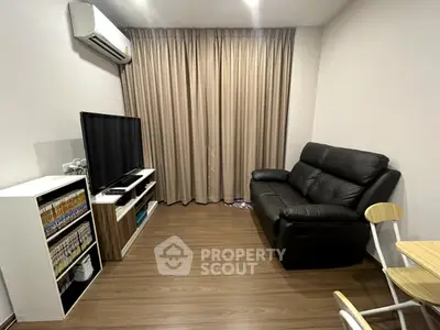 Cozy living room with modern furniture and entertainment setup, featuring a sleek TV and comfortable seating.