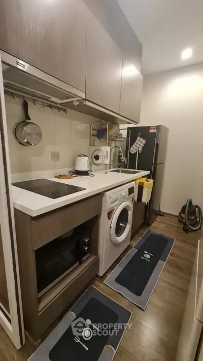 Modern compact kitchen with appliances and stylish cabinetry