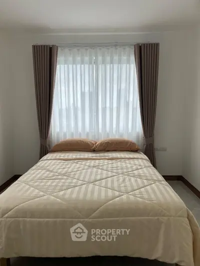 Cozy bedroom with elegant curtains and a neatly made bed, perfect for relaxation.