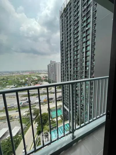 Stunning high-rise balcony view with cityscape and pool, perfect for urban living.