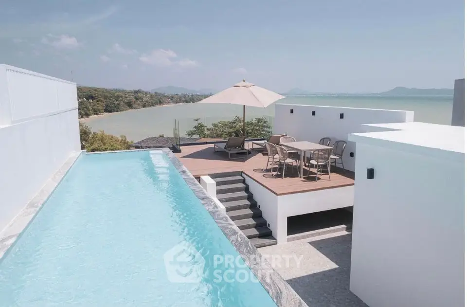Stunning rooftop pool with ocean view and modern outdoor seating area.