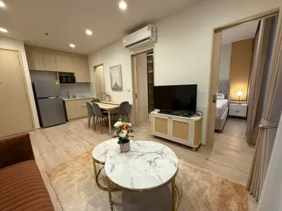 Modern open-plan living room with stylish furniture and kitchen area in a cozy apartment.
