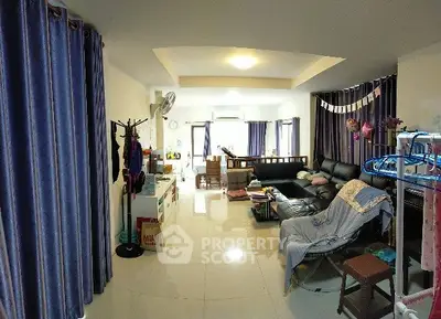 Spacious living room with modern decor and ample natural light, perfect for family gatherings.