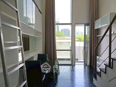 Modern loft apartment with high ceilings and large windows offering city views.