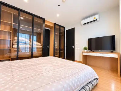 Modern bedroom with glass wardrobe and air conditioning in a stylish apartment.